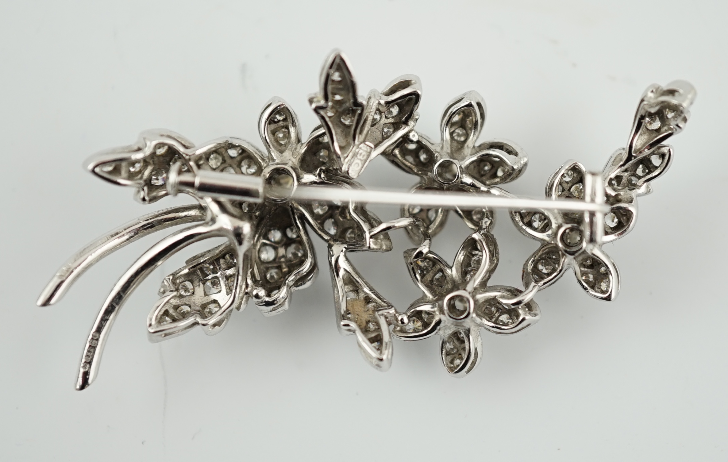 A late 1960's 18ct white gold and diamond cluster set floral spray brooch